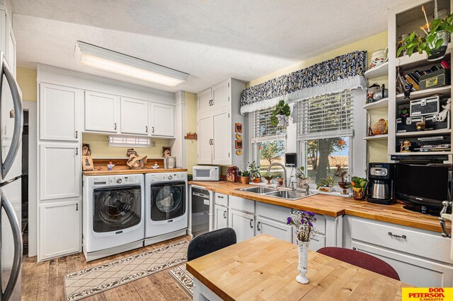 laundry room with a textured ceiling, light hardwood / wood-style floors, and sink