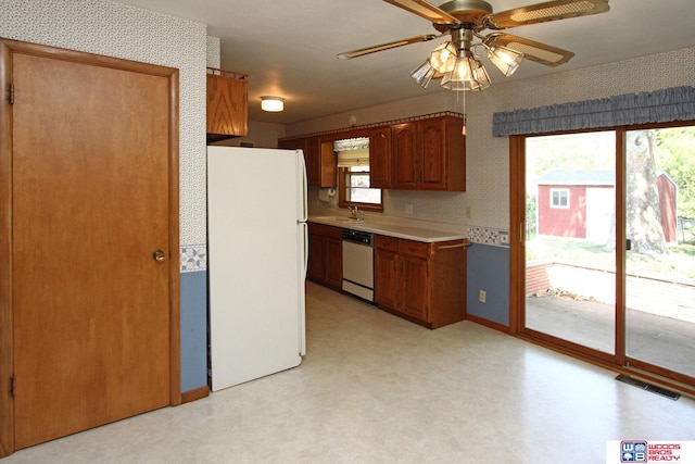 kitchen featuring white appliances, sink, and ceiling fan