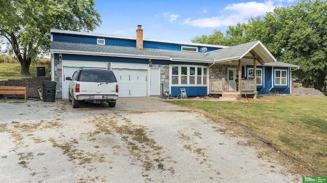 view of front of house with a front yard, a porch, and a garage