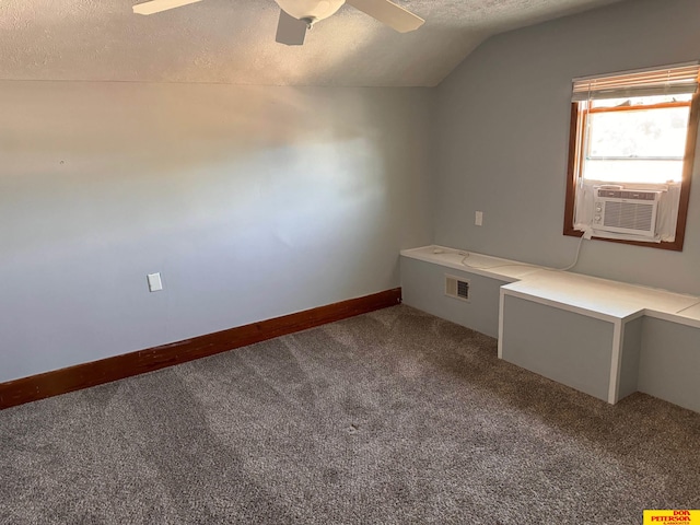 interior space featuring lofted ceiling, ceiling fan, carpet floors, and a textured ceiling