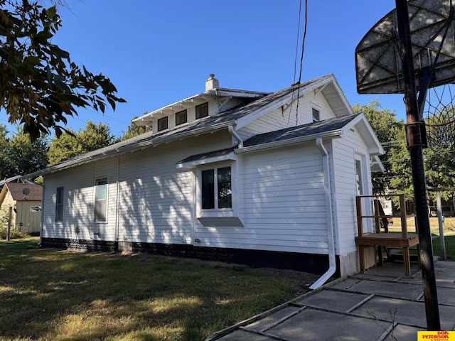 view of side of property with a lawn and a patio area