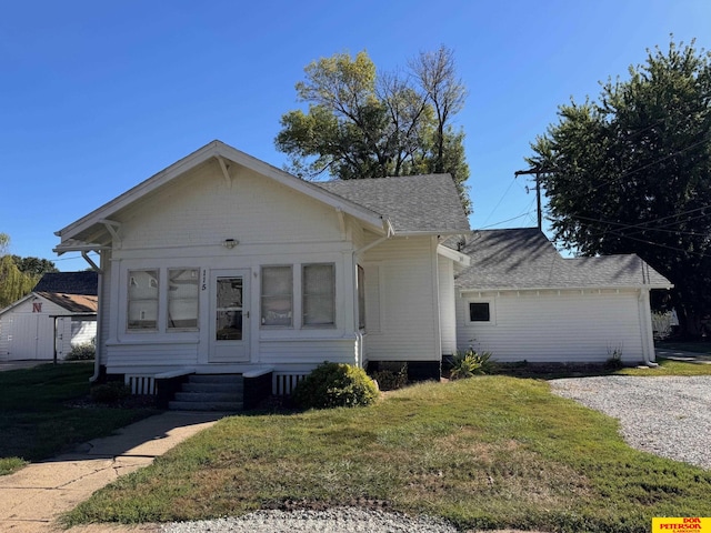 bungalow-style house featuring a front yard and roof with shingles