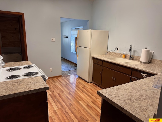 kitchen with dark brown cabinetry, white appliances, sink, and light hardwood / wood-style flooring