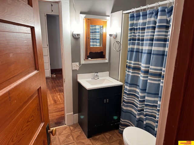 bathroom featuring curtained shower, wood-type flooring, vanity, and toilet