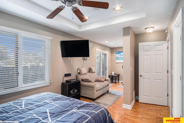 bedroom featuring a tray ceiling, hardwood / wood-style floors, and ceiling fan