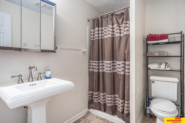 bathroom with sink, toilet, a textured ceiling, and a shower with shower curtain