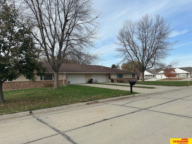 ranch-style home featuring a garage and a front lawn