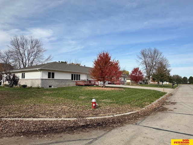 view of side of home with a lawn and a wooden deck