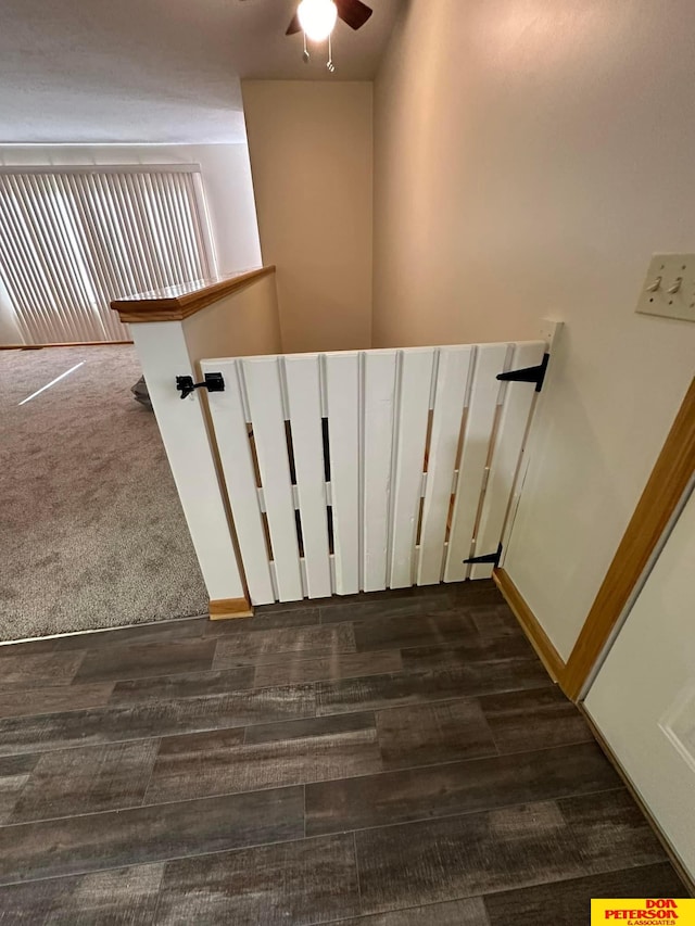 staircase with ceiling fan and carpet floors