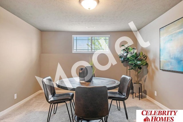 carpeted dining room featuring a textured ceiling