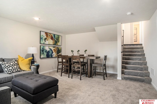 dining area featuring light colored carpet and a textured ceiling