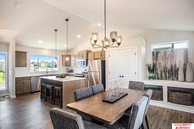 dining space with an inviting chandelier, lofted ceiling, dark hardwood / wood-style flooring, and a healthy amount of sunlight