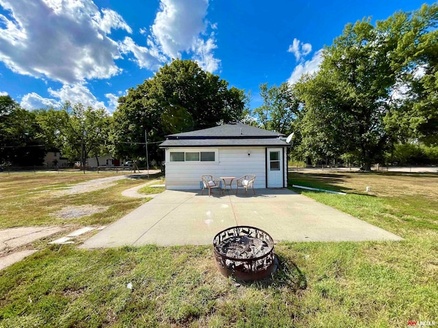 rear view of house with a lawn, a patio area, and a fire pit