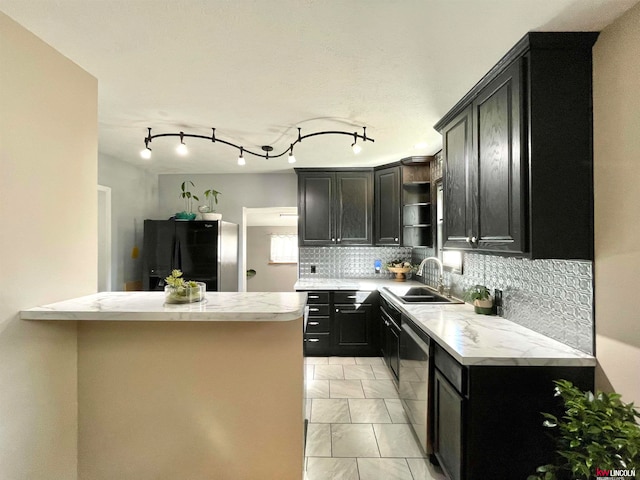 kitchen featuring track lighting, stainless steel appliances, backsplash, and sink