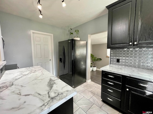 kitchen with decorative backsplash, black refrigerator with ice dispenser, and track lighting