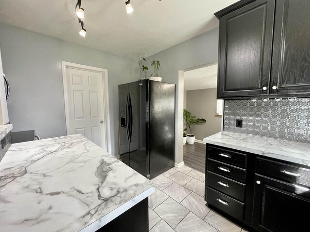3800 SW 16th St, Lincoln, NE 68522 - kitchen with light stone countertops, black fridge, and dark cabinetry