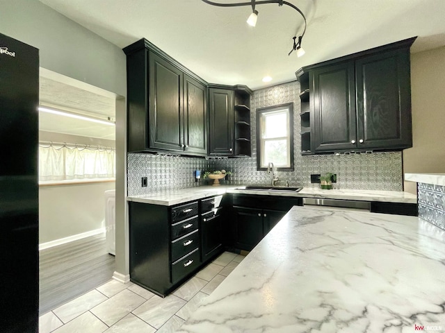 3800 SW 16th St, Lincoln, NE 68522 - kitchen featuring light stone counters, open shelves, dark cabinetry, decorative backsplash, and a sink