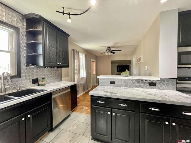3800 SW 16th St, Lincoln, NE 68522 - kitchen featuring a sink, decorative backsplash, appliances with stainless steel finishes, and dark cabinetry