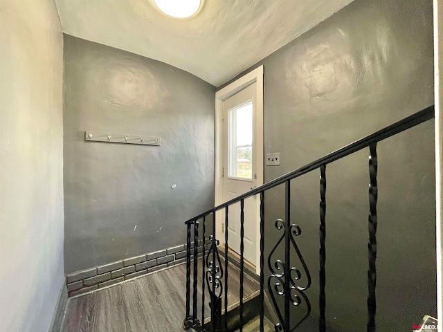 stairs with vaulted ceiling and hardwood / wood-style flooring