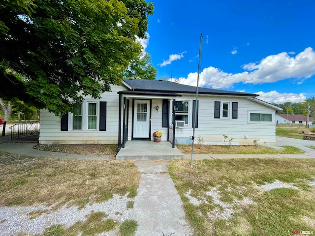 single story home with cooling unit and a front lawn