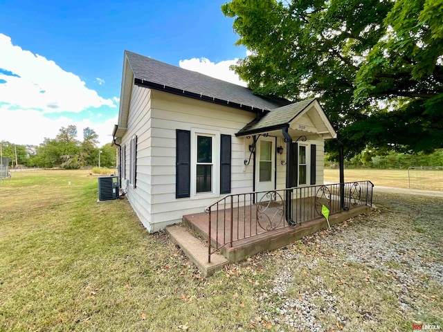 view of front facade featuring a front yard, a porch, and central air condition unit