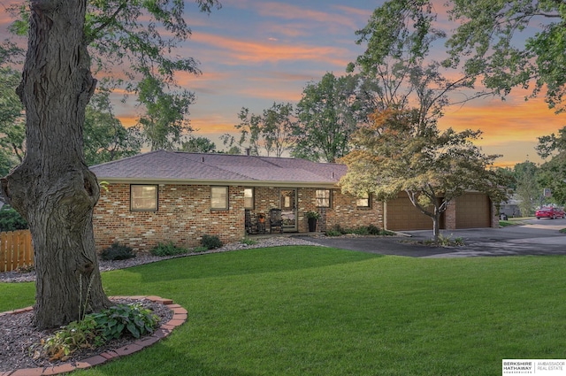 ranch-style house featuring a lawn and a garage