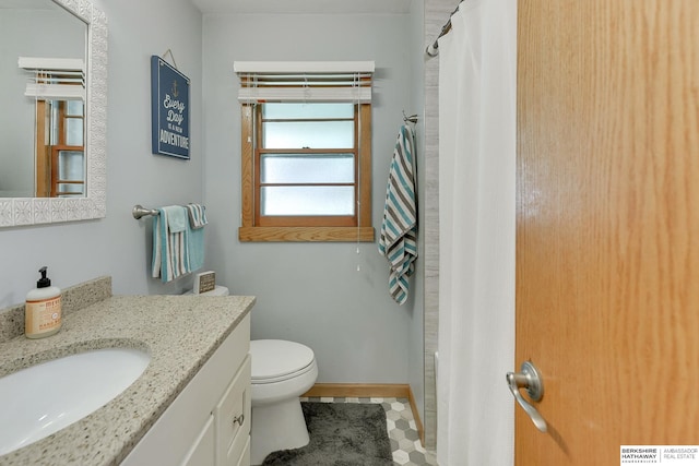 bathroom with curtained shower, vanity, toilet, and tile patterned floors