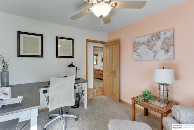 carpeted home office featuring ceiling fan