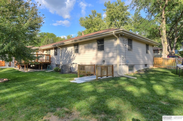 rear view of house featuring a lawn, central AC, and a deck