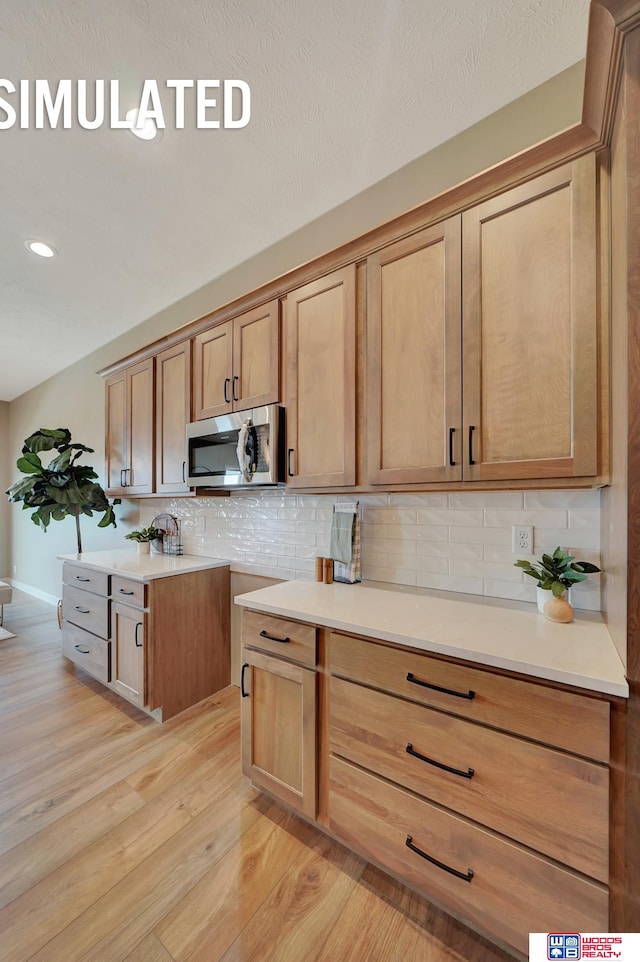 kitchen with light wood-type flooring and backsplash