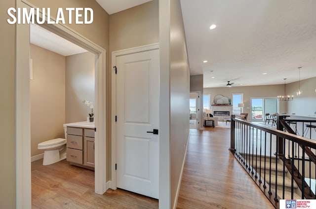 hallway featuring light hardwood / wood-style flooring and a notable chandelier