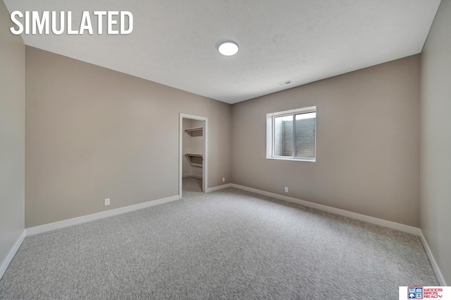 unfurnished bedroom featuring light carpet, a spacious closet, and a closet