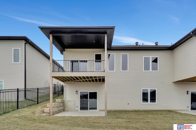 back of property featuring a yard, a patio area, and a balcony