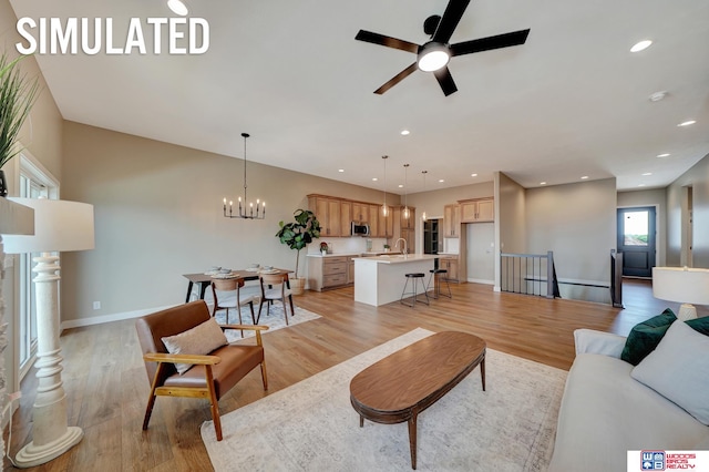 living room with light hardwood / wood-style floors and ceiling fan with notable chandelier