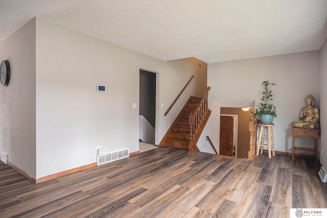 living room with a textured ceiling, a baseboard heating unit, and dark wood-type flooring