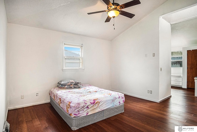 bedroom featuring ceiling fan, a textured ceiling, vaulted ceiling, and dark hardwood / wood-style flooring