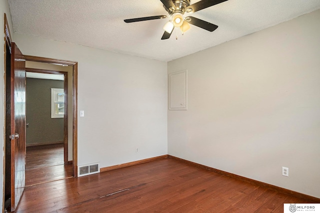 unfurnished room with a textured ceiling, dark hardwood / wood-style floors, and ceiling fan