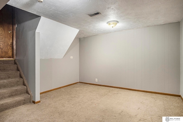 bonus room featuring a textured ceiling and carpet