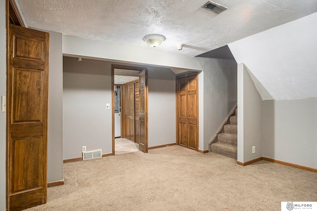 bonus room featuring carpet floors, a textured ceiling, and lofted ceiling