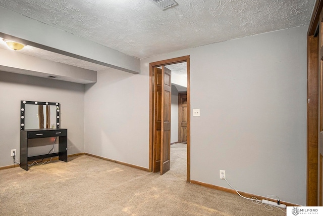 interior space featuring light carpet and a textured ceiling