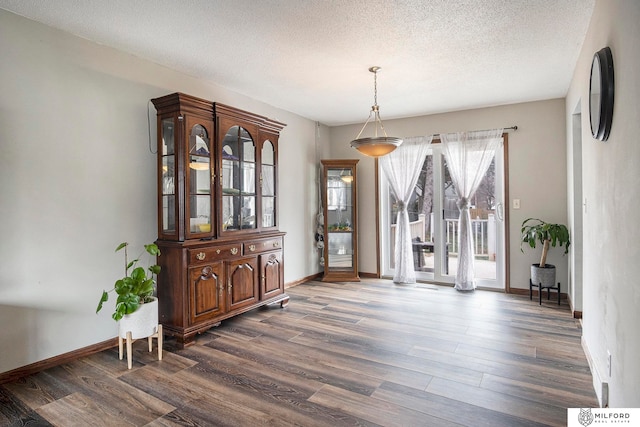 dining area with a textured ceiling and dark wood-type flooring