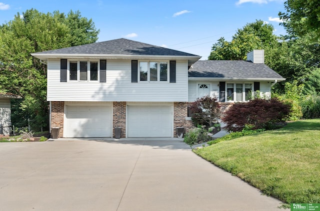 tri-level home featuring a garage, a front lawn, and central AC