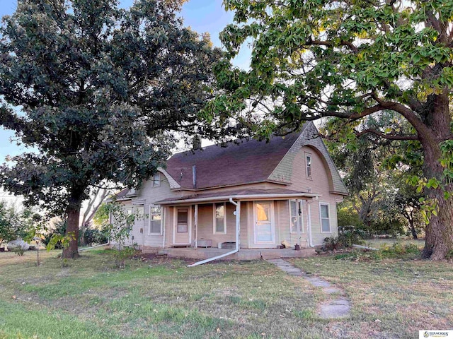 view of front of house with covered porch and a front lawn