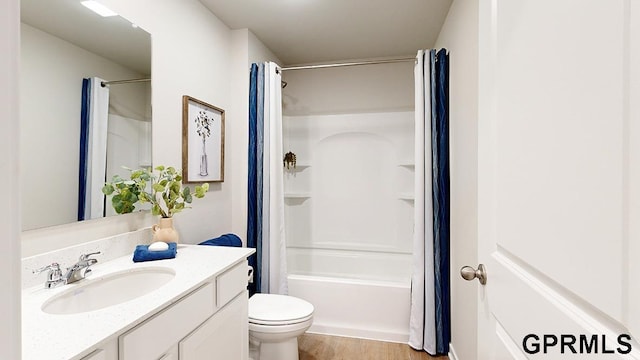 full bathroom featuring hardwood / wood-style floors, shower / tub combo with curtain, vanity, and toilet