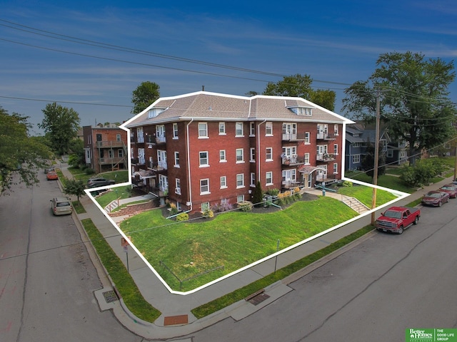 view of front of home with a balcony and a front lawn