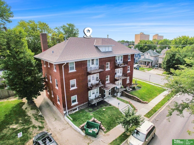 exterior space featuring a balcony and a front lawn