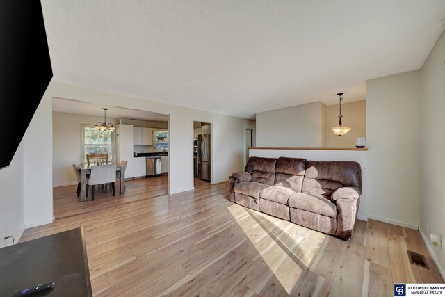 living room featuring light hardwood / wood-style flooring and a chandelier