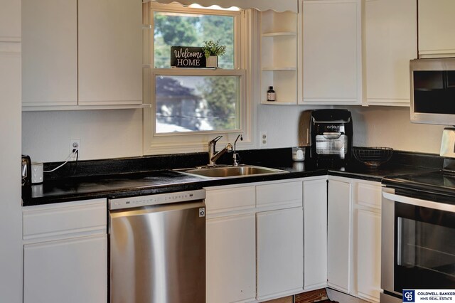 kitchen featuring white cabinets, appliances with stainless steel finishes, and sink