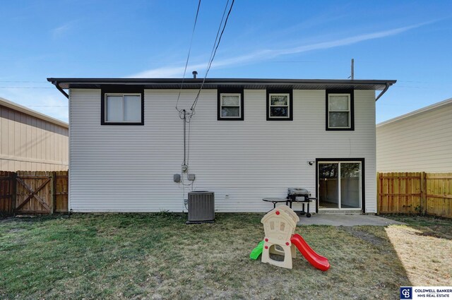 back of property with central AC unit, a patio area, and a yard