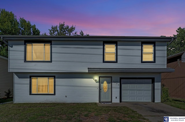 view of front of property featuring a garage and a lawn